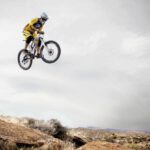 Adventure Races - Person Riding Bike Making Trek on Thin Air