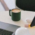 Melbourne Coffee - A laptop on a table with a cup of coffee