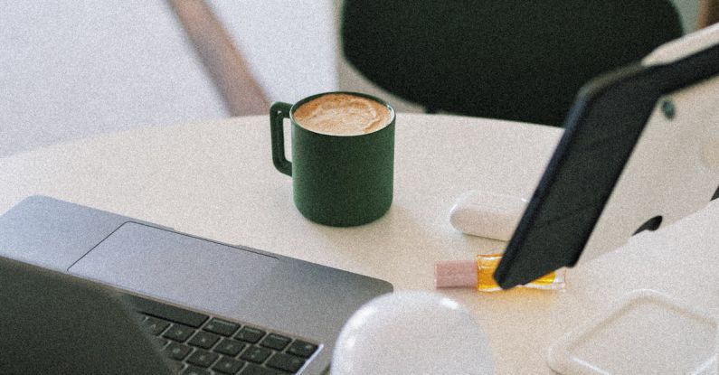 Melbourne Coffee - A laptop on a table with a cup of coffee